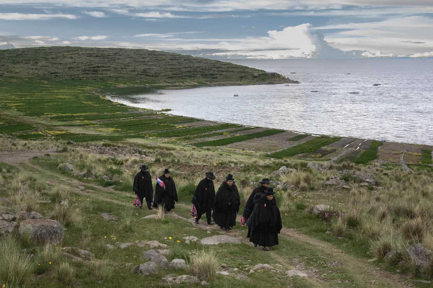 Autoridades originarias caminando por la orilla del lago Titicaca