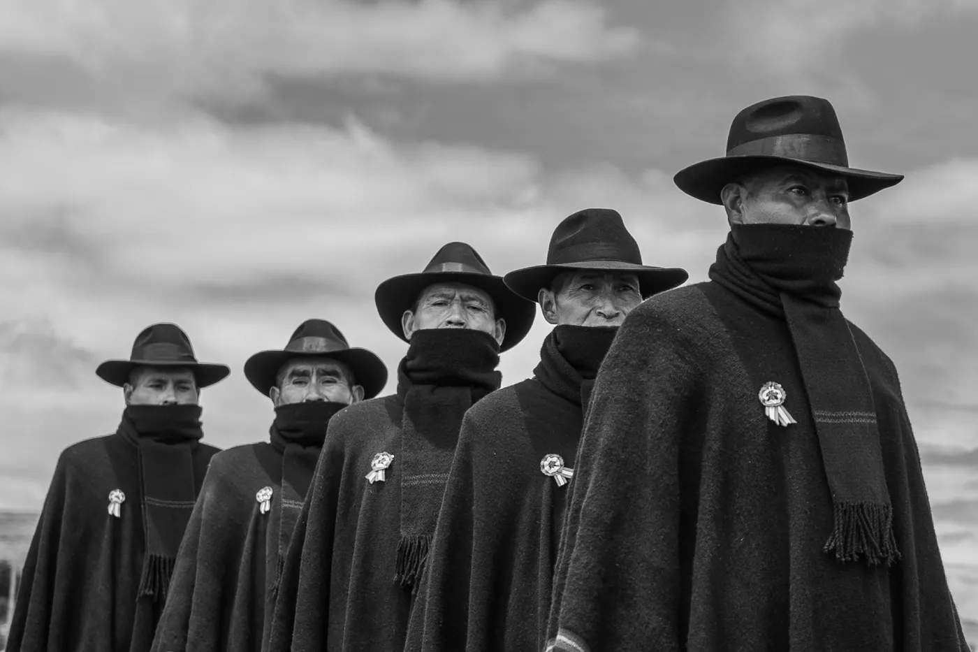 Cinco jilaqatas formados bajo un cielo de nubes